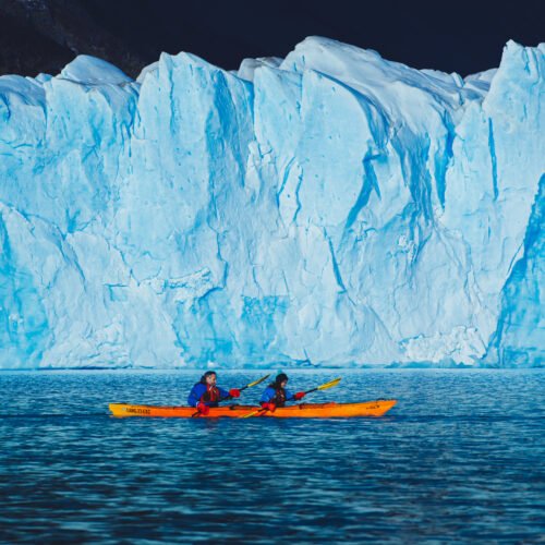 Imagen de dos personas realizando kayak sobre el lago argentino con el glaciar Perito Moreno de Fondo